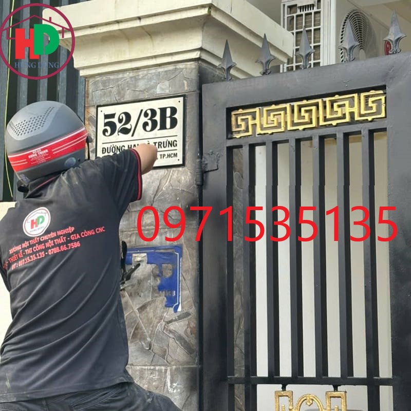 nhân viên hùng dũng dán bảng số nhà cho khách tại dĩ an